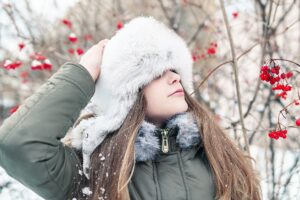 Frau mit warmer Mütze im Schnee