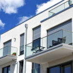 Moderne Balkone mit Rolläden, verglast mit Metall-Geländer an Neubau-Hausfront