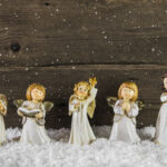 Einer Schar von Engeln aus Holz, nebeneinander in künstlichem Schnee