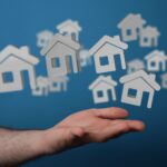 Hand mit schwebenden Haussymbolen | Immobilienmakler Neustadt in Holstein